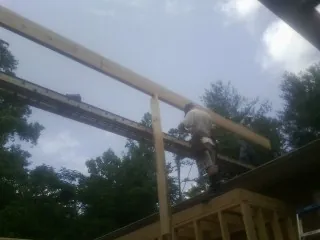 Carpenter setting a ridge beam over a new addition frame — Ice Dam Removal by Roofing Brothers in Milledgeville